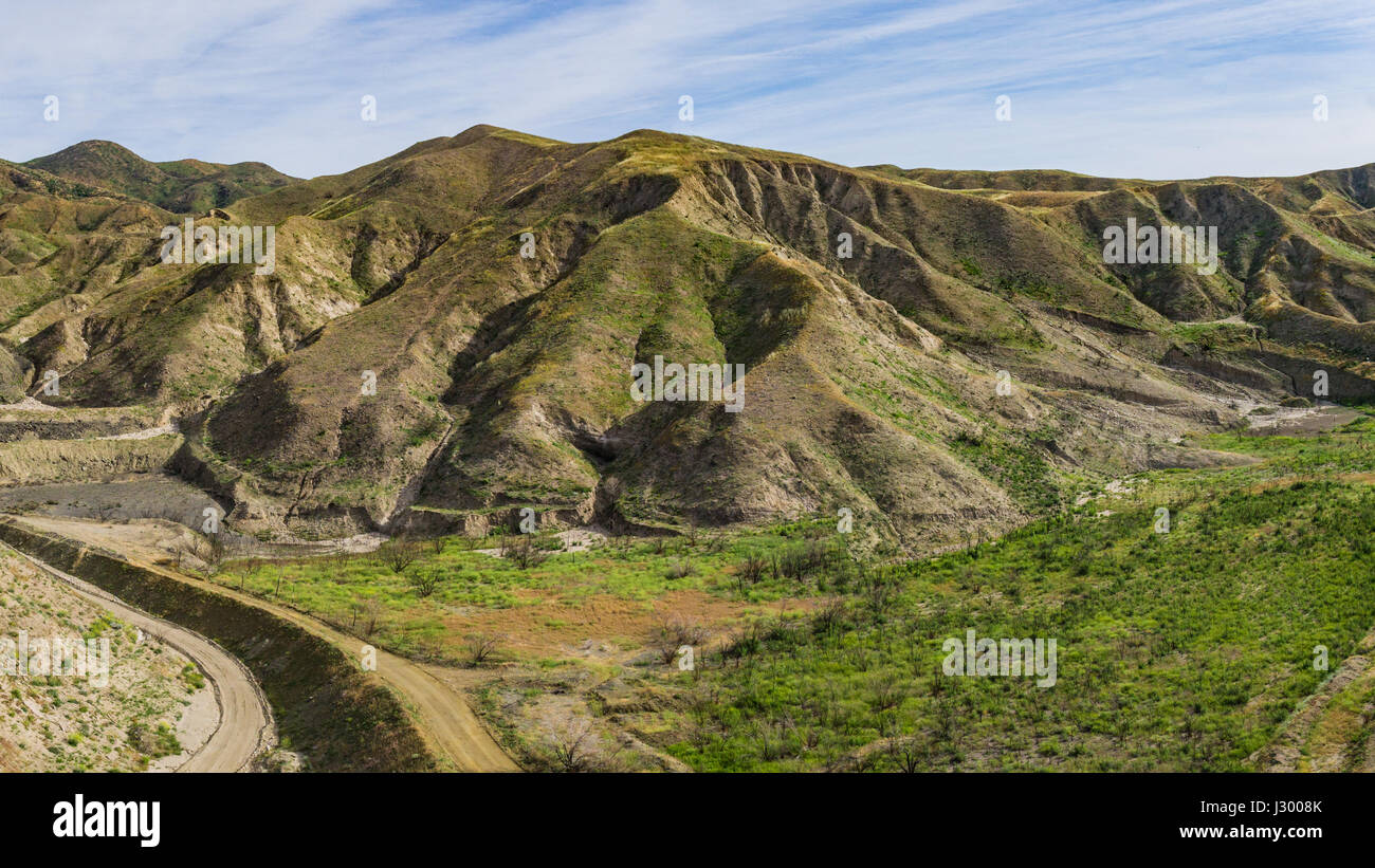 Dirt road leads into California canyon lands. Stock Photo