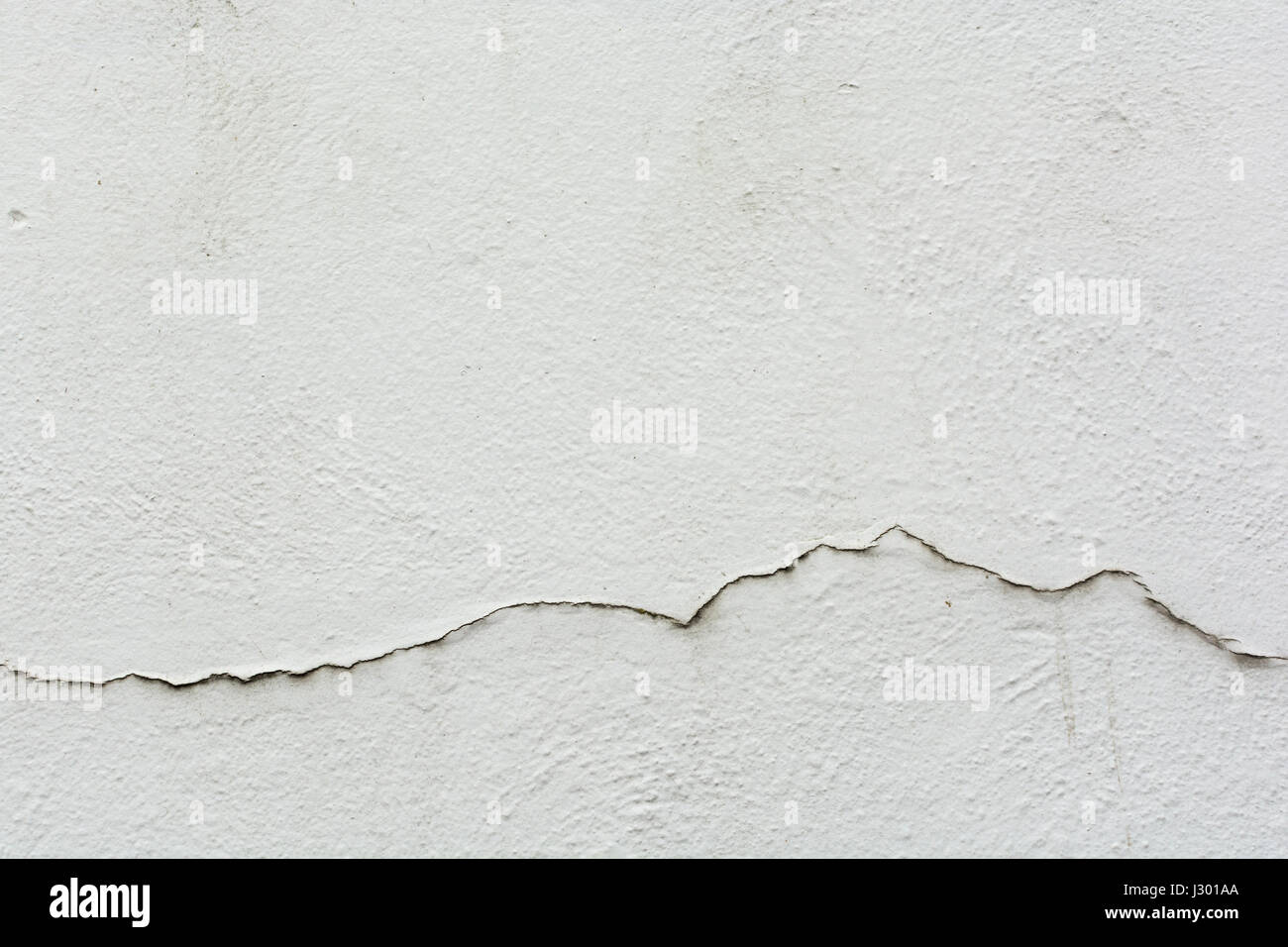 Cracks in a building outer wall - metaphor for the concept of rising and falling sales, irregular, sales graph, performance graph line, and similar. Stock Photo