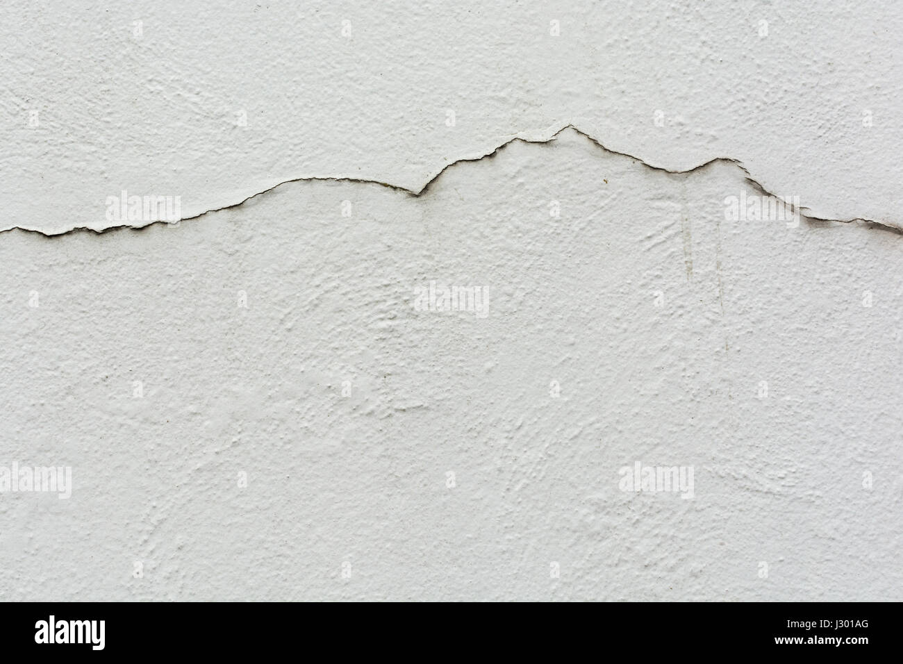 Cracks in a building outer wall - metaphor for the concept of rising and falling sales, irregular, sales graph, performance graph line, and similar. Stock Photo