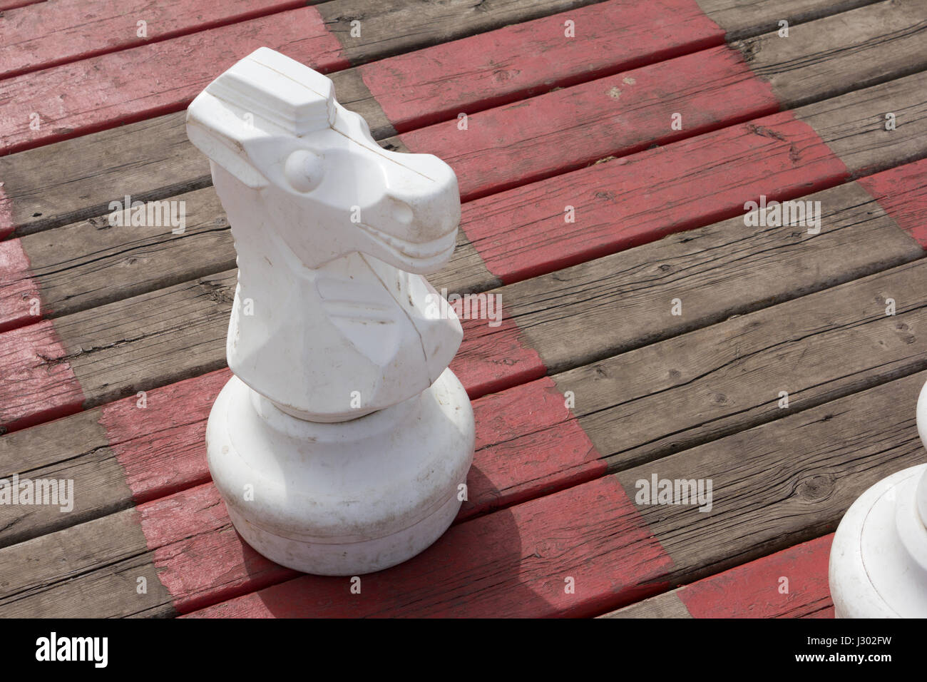 A large knight chess piece on an oversized board. Stock Photo