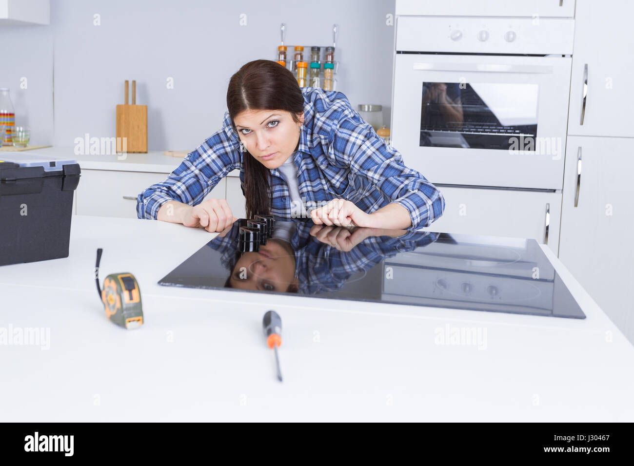 Woman fitting ceramic hob into kitchen unit Stock Photo Alamy