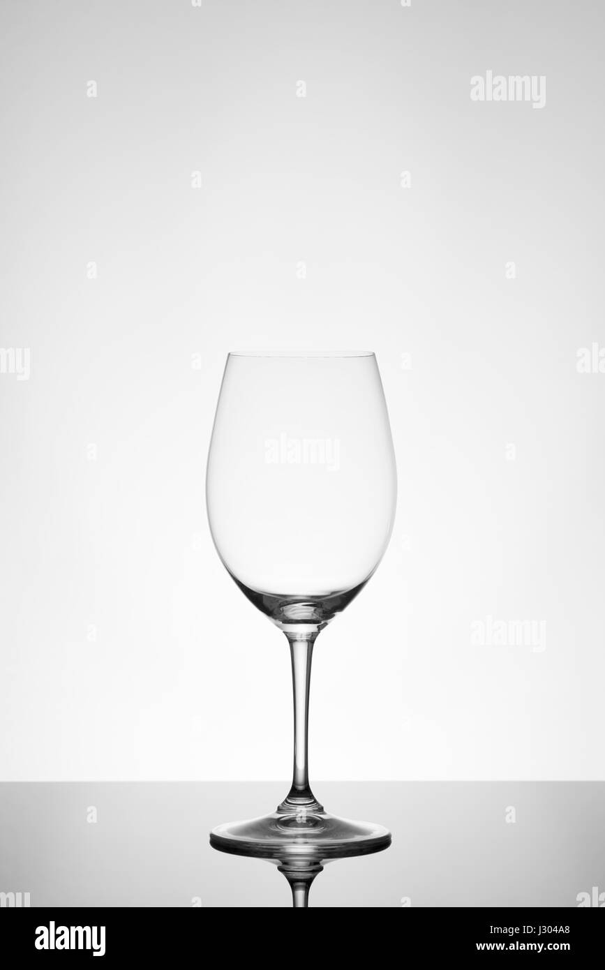 Empty wine glass on reflective tabletop, black and white Stock Photo