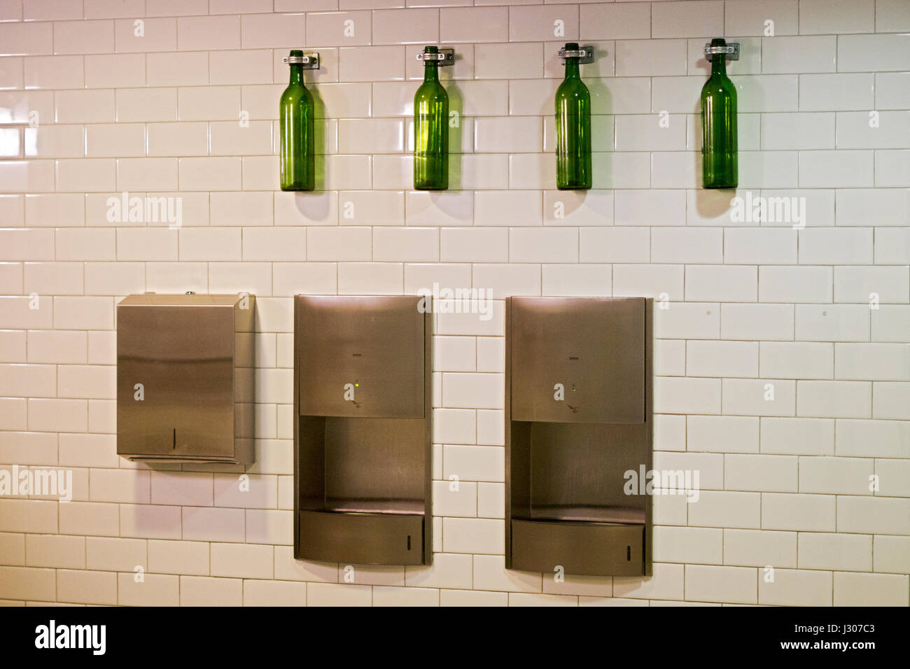 A wall in the mans room at EATALY with olive oil bottles as decoration. In the Flatiron section of Manhattan, New York City Stock Photo
