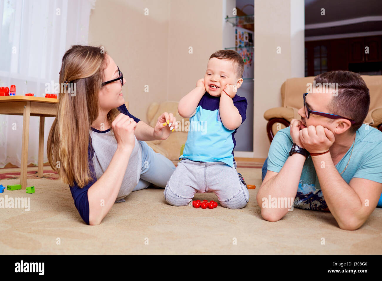 Happy family having fun playing on the floor in room Stock Photo