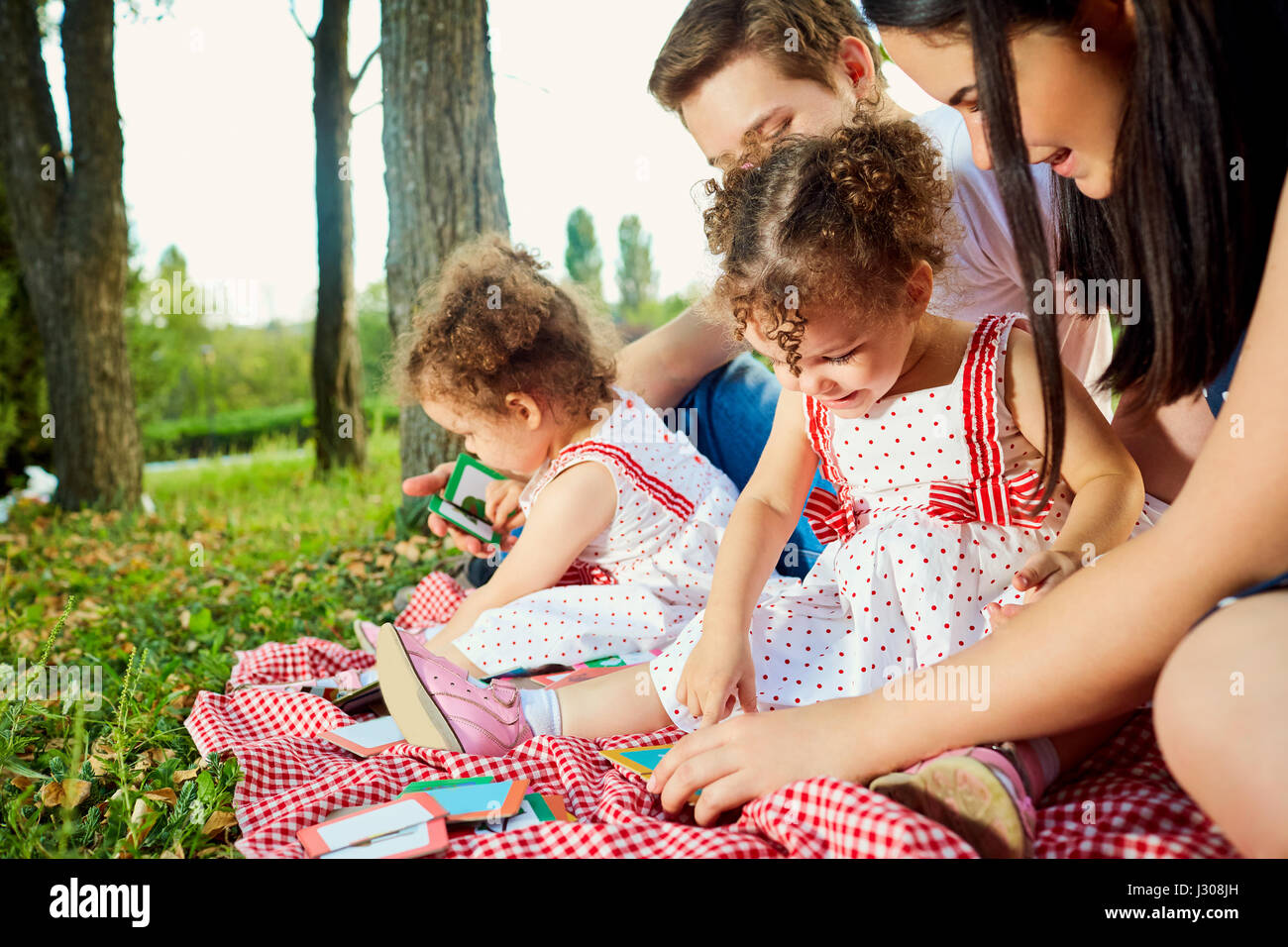 Children and parents play developing games in the park on grass. Stock Photo