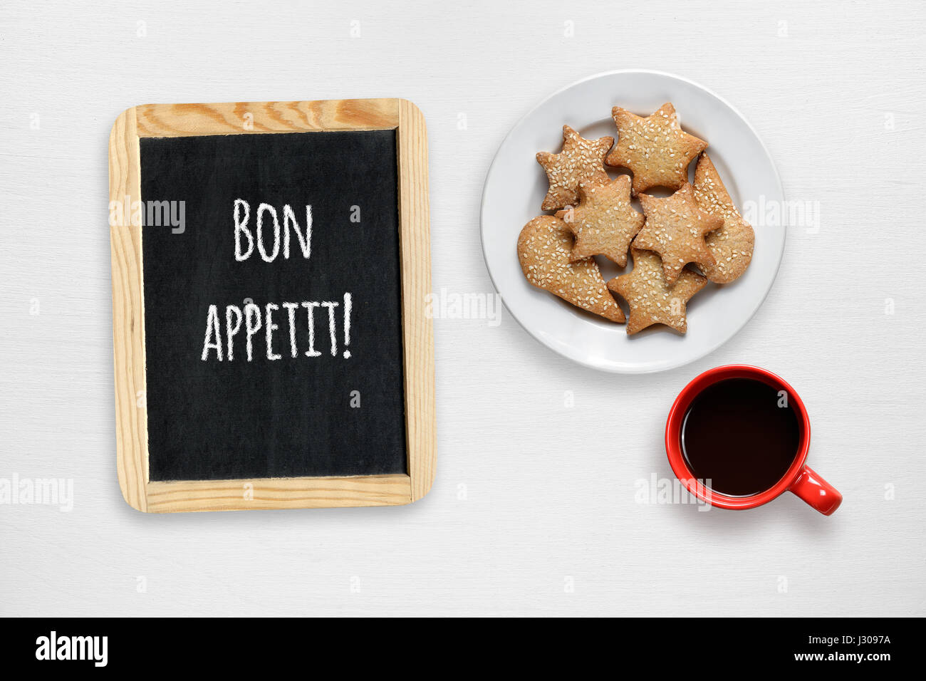 Cookies, coffee cup and small blackboard with Bon appetit wishes on white table Stock Photo Alamy