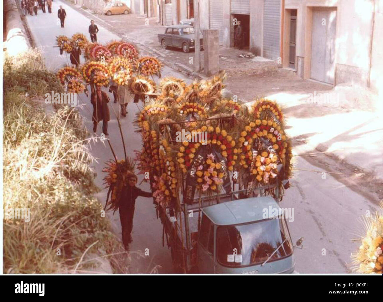 An old photograph from Alcamo depicts funeral flower wreaths, symbolizing local customs and traditions in mourning practices from the past century in the region. Stock Photo