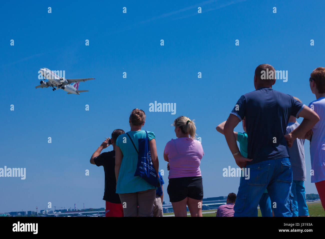 Plane spotters watching an airplane take off from Warsaw Okecie, Chopin airport in Warsaw, Poland Stock Photo