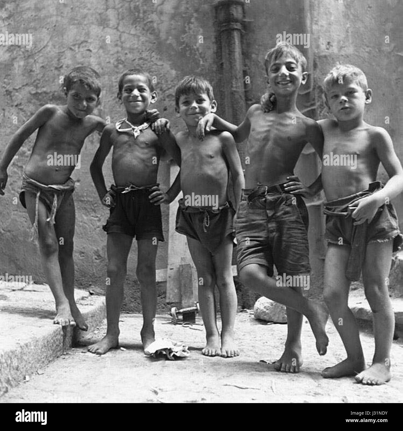 The term 'scugnizzi' refers to the street children of Naples, Italy. Historically, they were known for their independence, often surviving through small trades or by living off the streets. This social group became an iconic part of Naples' cultural history during the 19th and early 20th centuries, symbolizing resilience and the challenges of urban poverty. Stock Photo