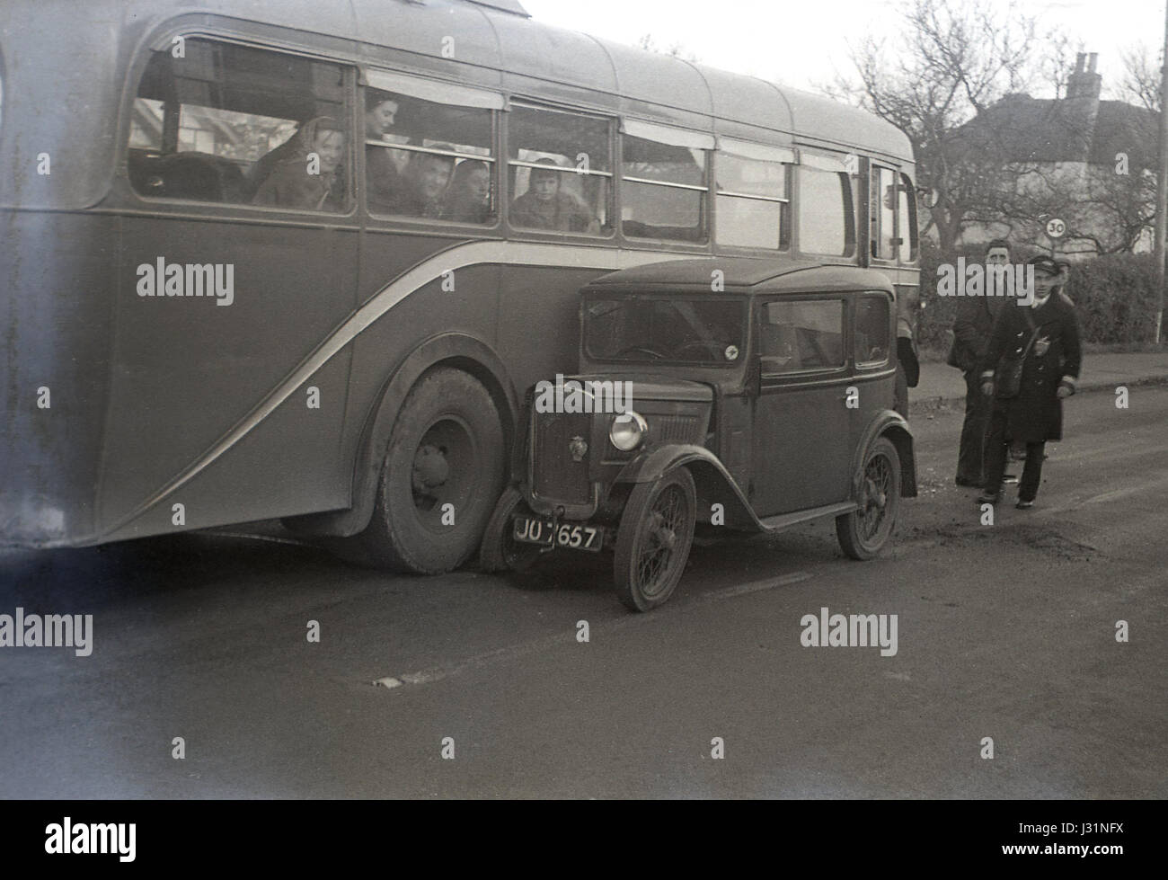 1950, a single-decker passenger bus in a collision with a small pre-ww2 Austin 7 motor car, England, UK. Stock Photo
