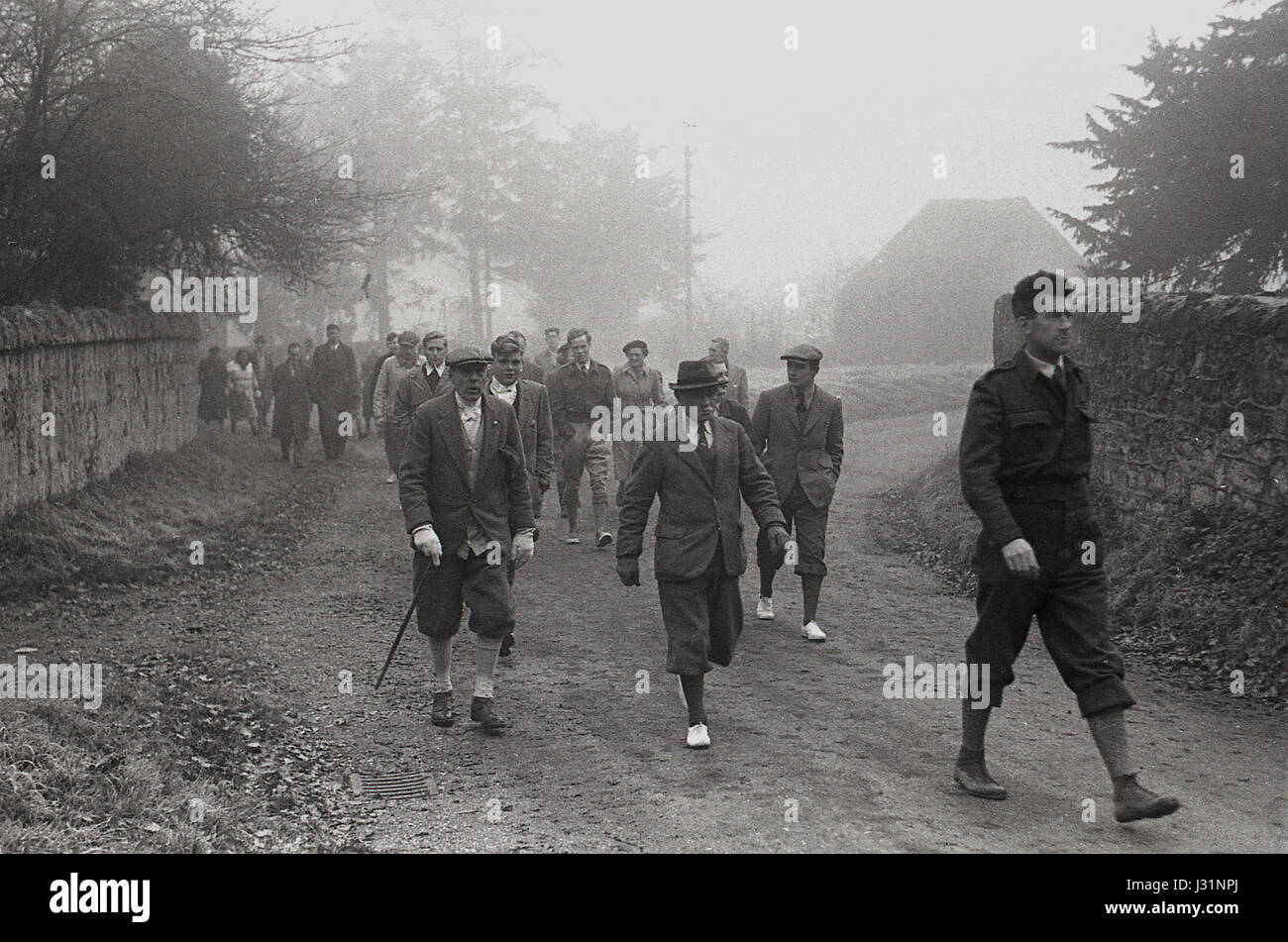 1950s, 'a hunt field', early morning and a group of members and guests, with men wearing traditional walking trousers of 'plus twos' and 'plus fours'' follow a hunt. Stock Photo