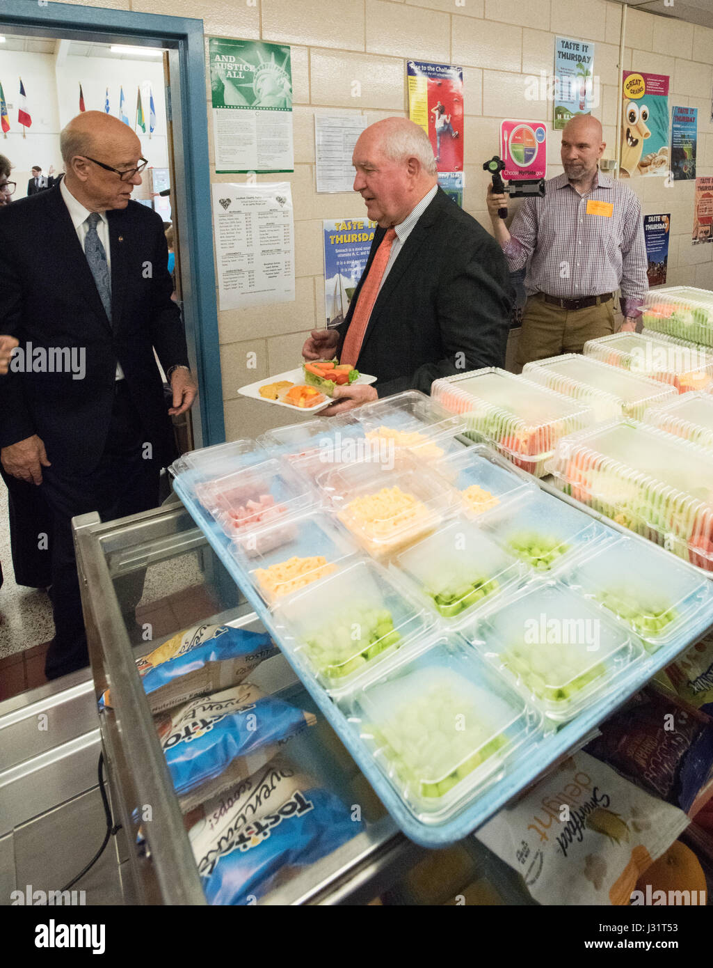 Leesburg, Virgina, USA. 1st May, 2017.  U.S. Secretary of Agriculture Sonny Perdue and Senator Pat Roberts, left, grab lunch during a visit to Catoctin Elementary School May 1, 2017 in Leesburg, Virginia. Earlier Perdue signed an interim rule removing healthy lunch guidelines in the National School Lunch Program. The healthy lunch rules were championed by former First Lady Michelle Obama. Credit: Planetpix/Alamy Live News Stock Photo