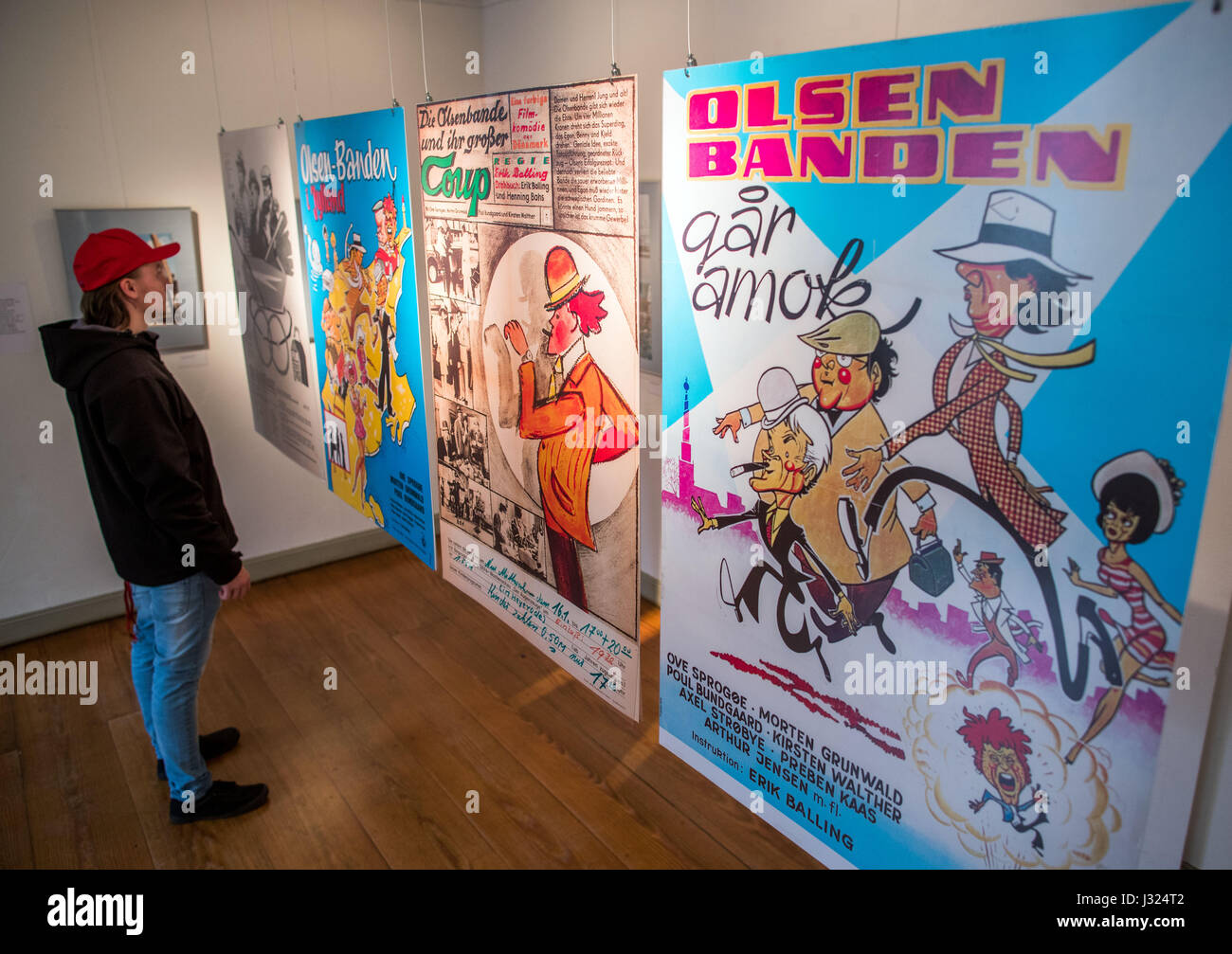Schwerin, Germany. 2nd May, 2017. A visitor looks at historical movie posters at a special exhibition on the movie history of the Olsen Gang in Schwerin, Germany, 2 May 2017. 60-year-old Jes Holtsoe, who played the teenager Borge in the popular Danish crime comedies of the Olsen Gang, not only opened the exhibition on the Olsen Gang movies, which were especially popular in Eastern Germany. Credit: dpa picture alliance/Alamy Live News Stock Photo