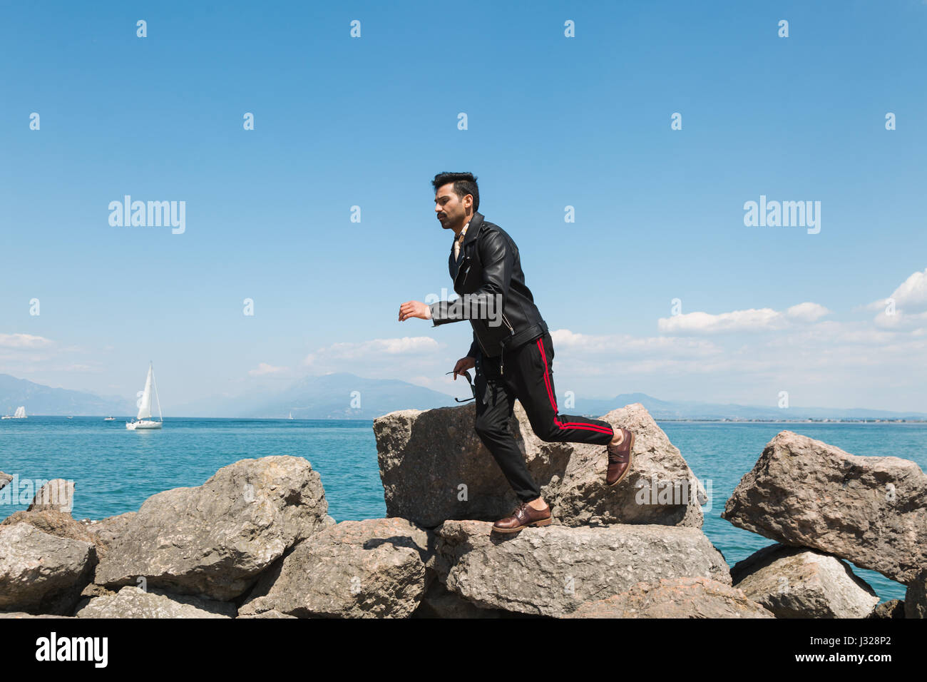 Handsome Indian man jumping in a vacation context. Street fashion and style. Stock Photo