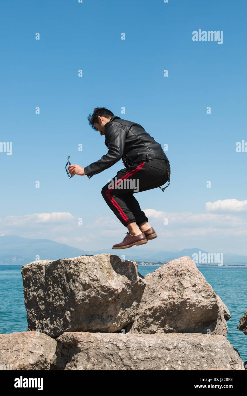 Handsome Indian man jumping in a vacation context. Street fashion and style. Stock Photo