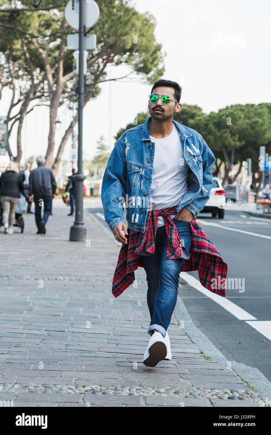 Handsome Indian man posing in an urban context. Street fashion and style. Stock Photo