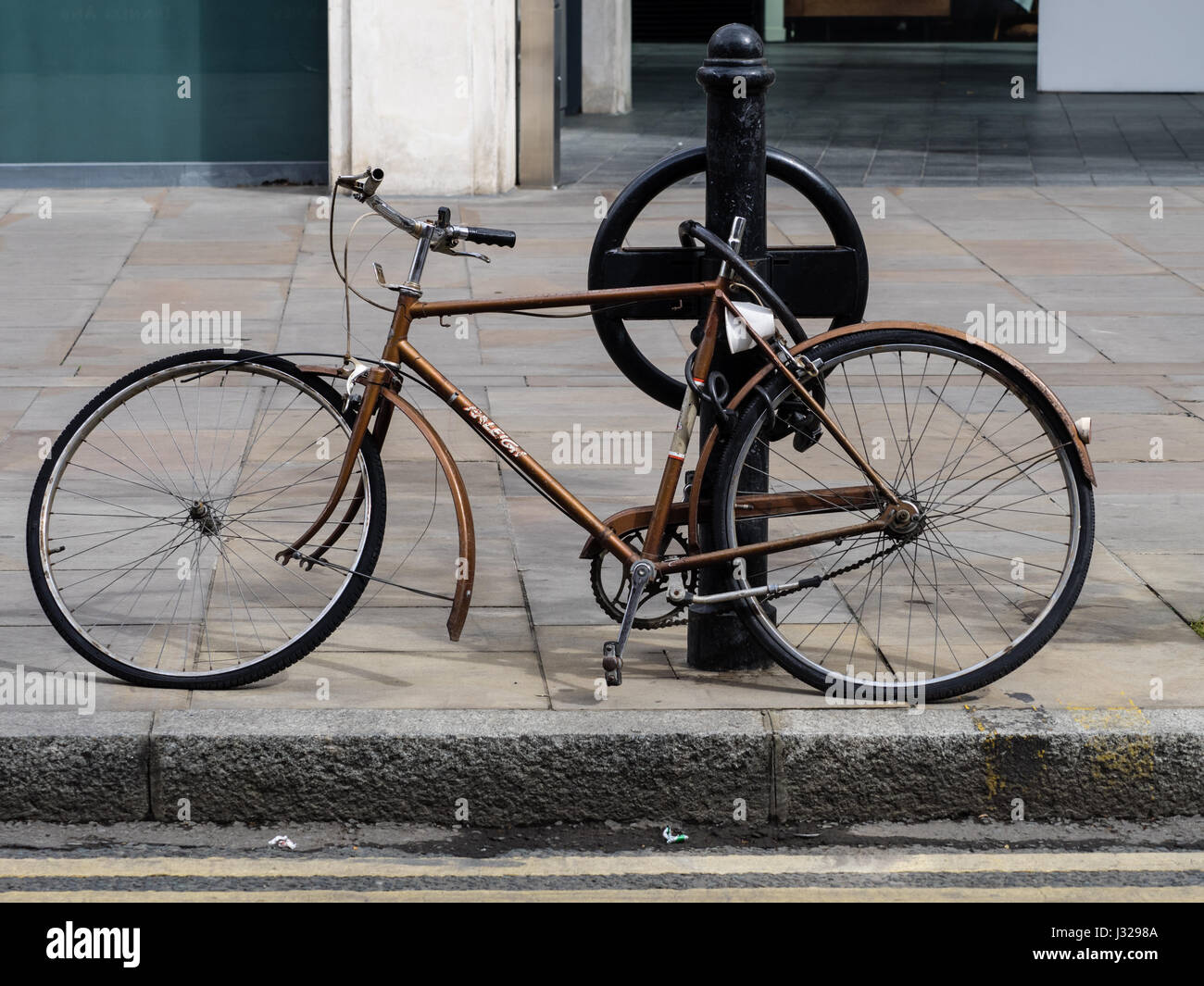 A vandalised bike locked to a post near London's Spitalfields Market Stock Photo