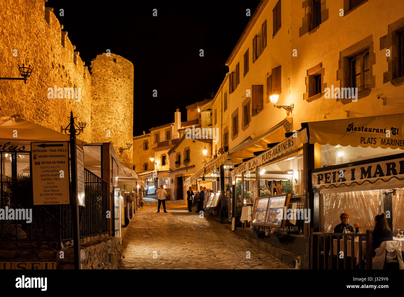 Tossa de Mar at night, cobbled alley with restaurants, cafes next to