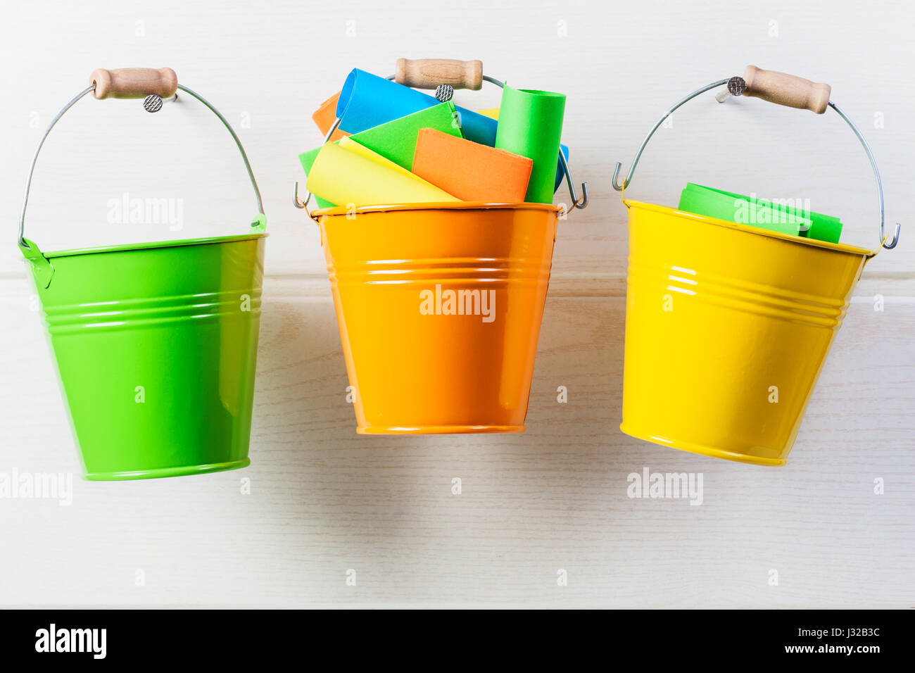 Bucket list concept. Buckets with colorful paper notes hanging on white