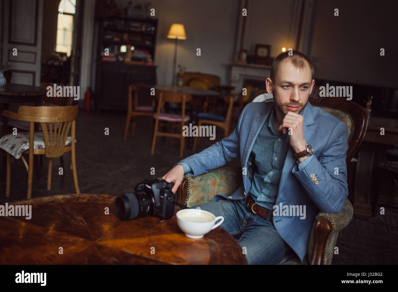 Young man sits and enjoys coffee in the morning. Portrait in the