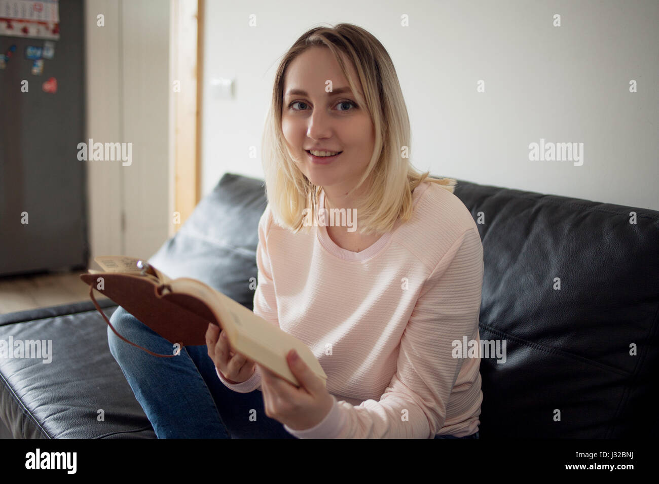 Young woman with planner. Portrait in the interior, on the couch at ...