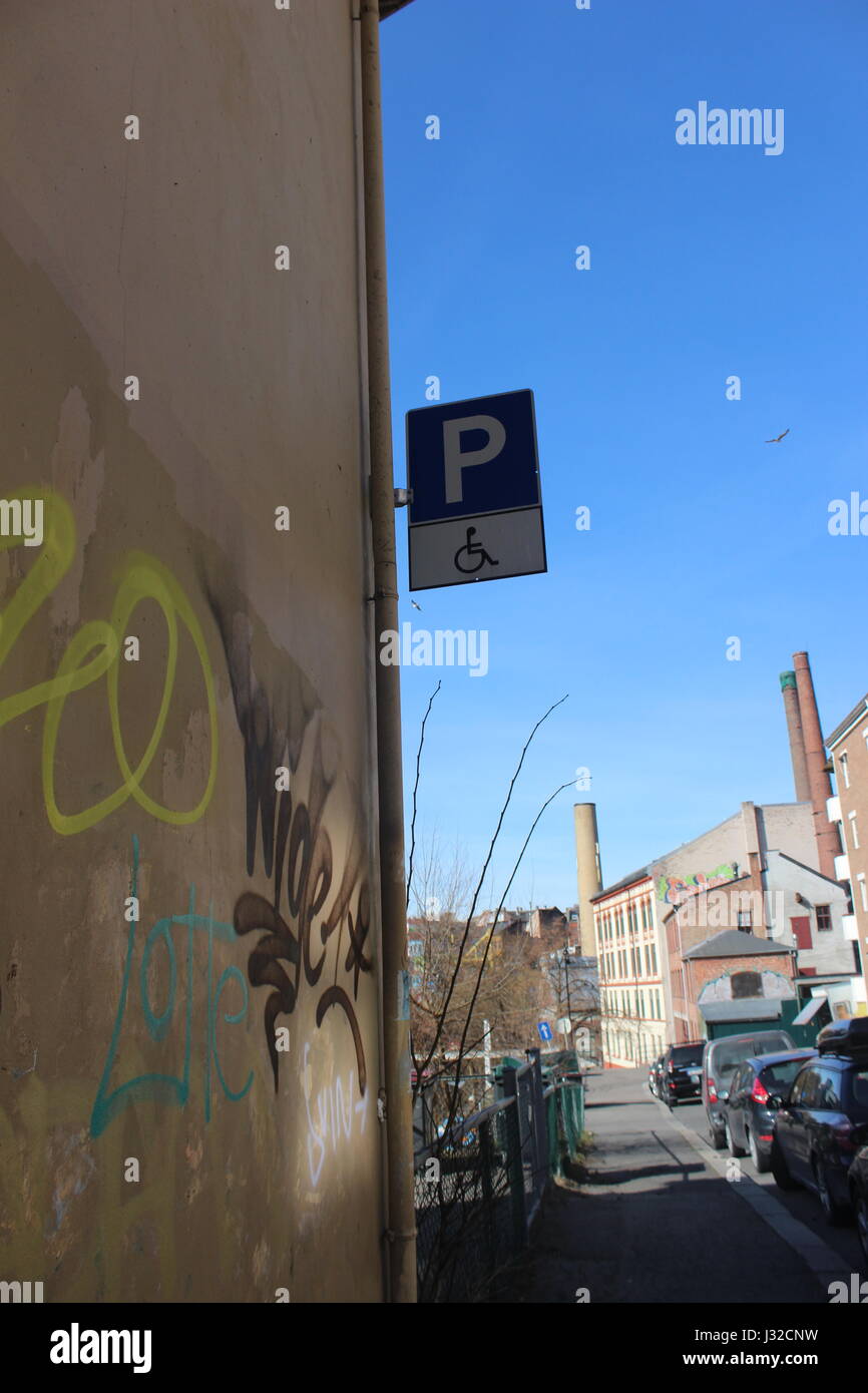 Handicap parking sign on wall with graffiti in Oslo, Norway Stock Photo