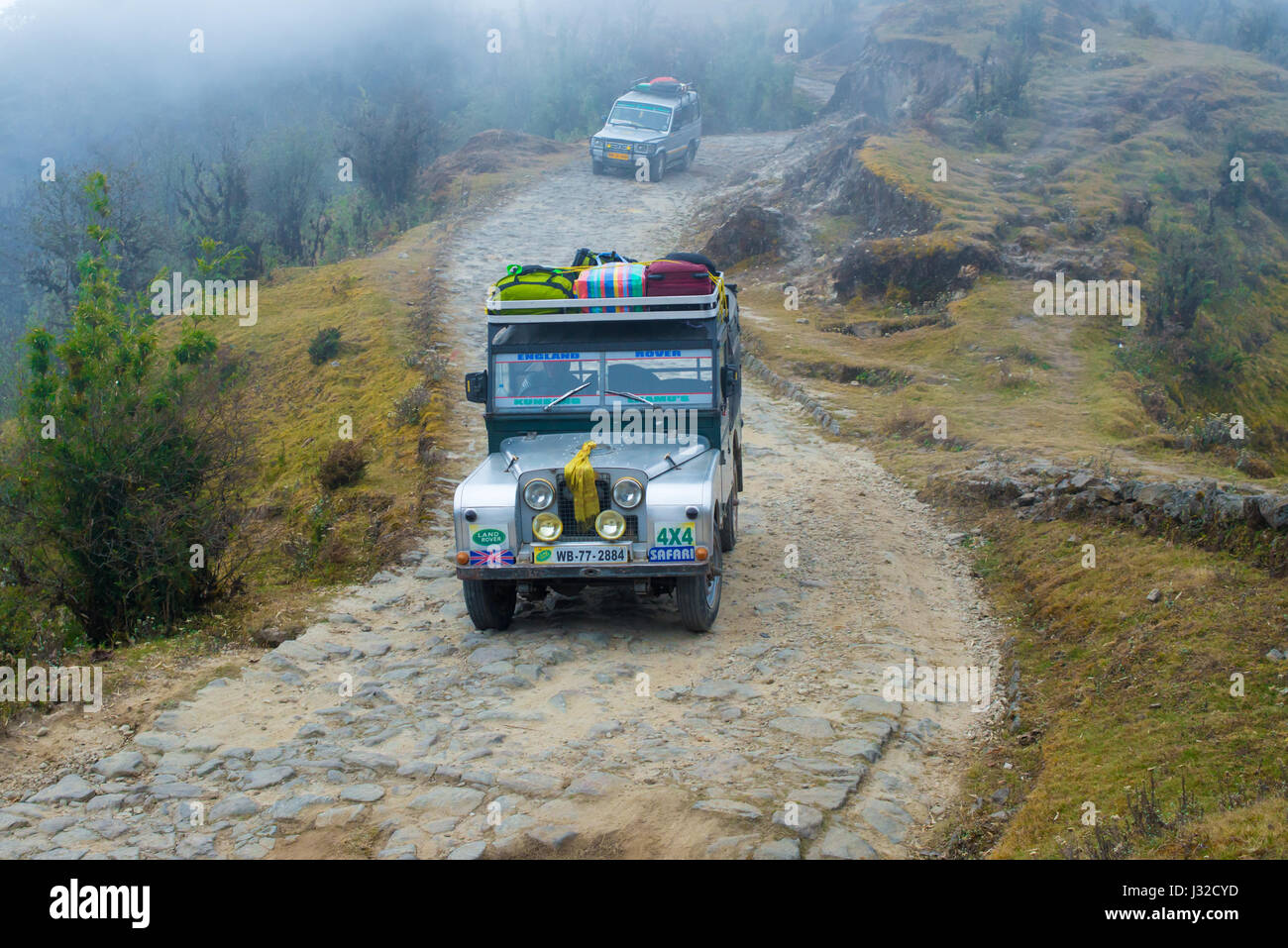 DARJEELING, INDIA - NOVEMBER 28, 2016: two jeeps climb a gravel road through Singalila National Park.  It is the route to Sankakphu and Phalut, the tw Stock Photo