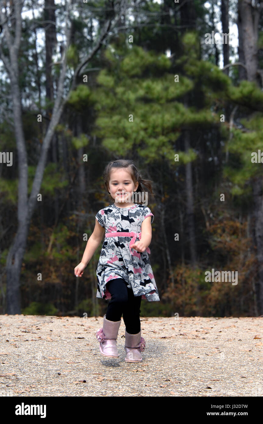 Little Girl Rushing Little girl runs joyfully downhill at her home in the country. Her hair ...