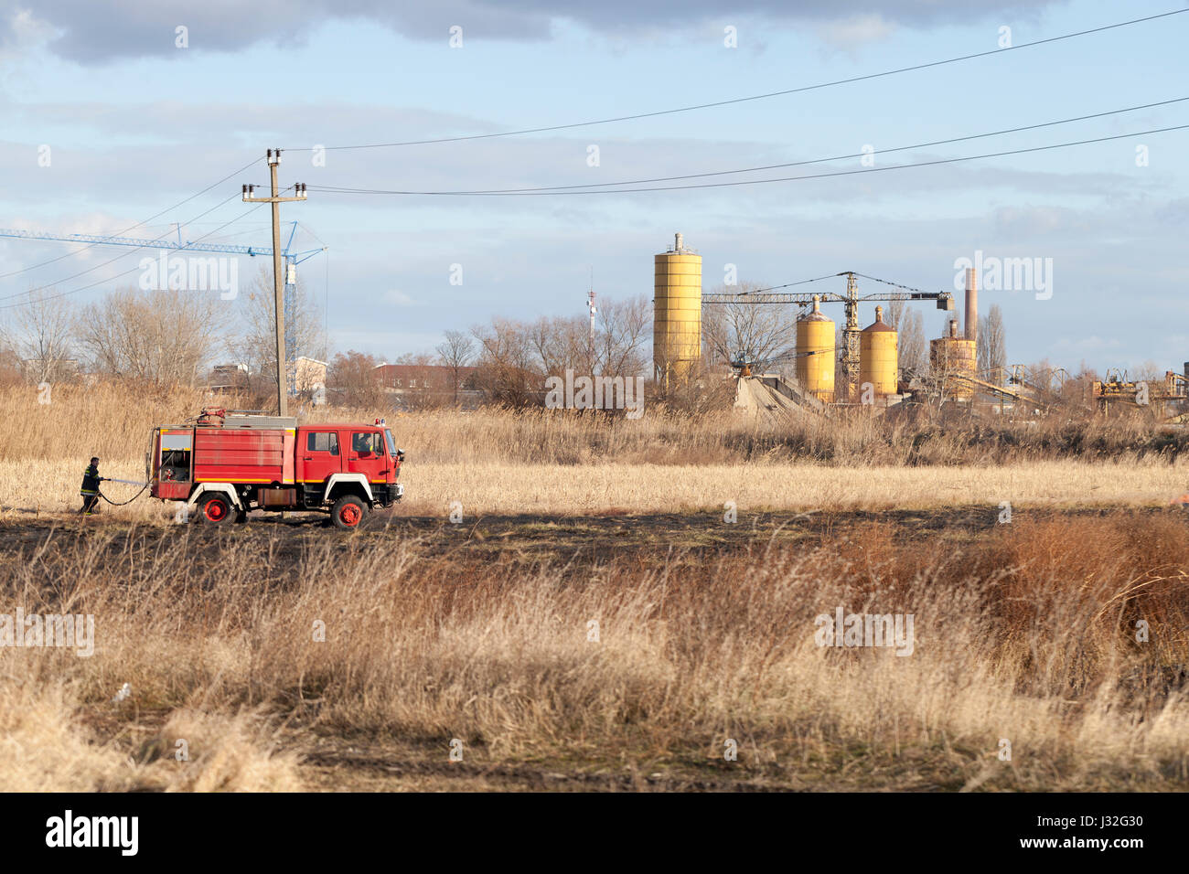 Firefighting on the field. Firefighter with a truck and a fire hose