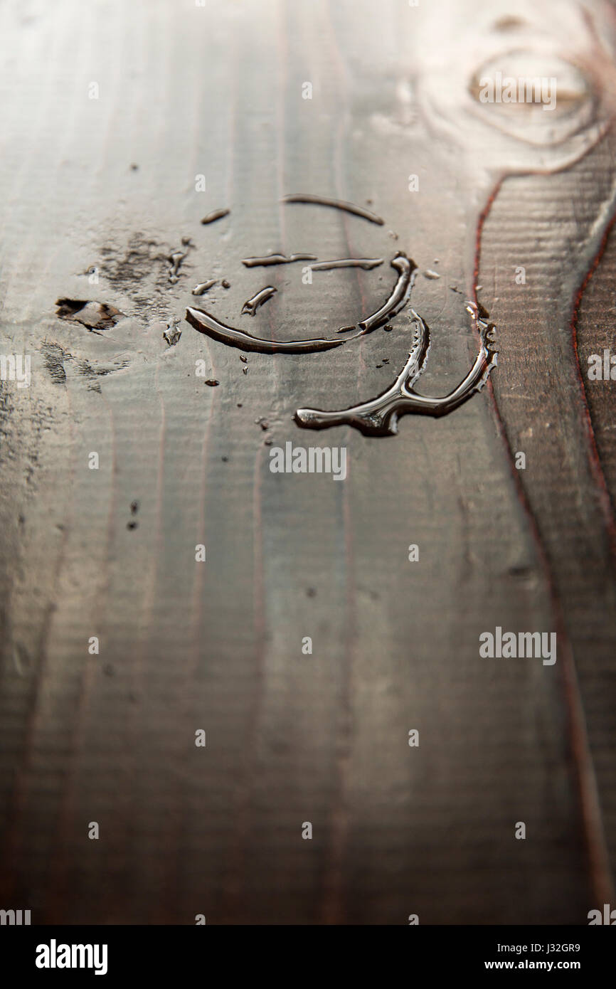 Three quarters view of water rings on a dark wood surface with copy
