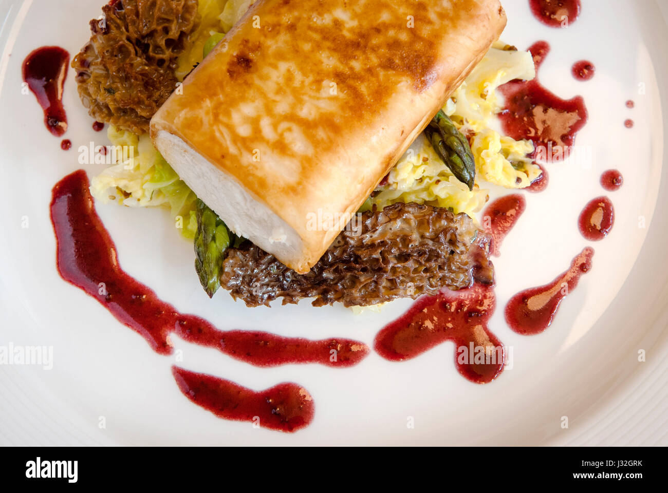 Overhead photo of phyllowrapped halibut strudel on a bed of asparagus