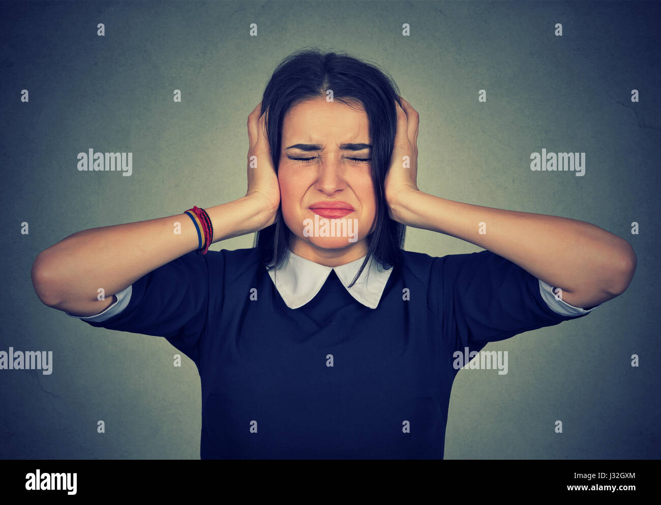 Stressed woman upset frustrated covering her ears with hands isolated