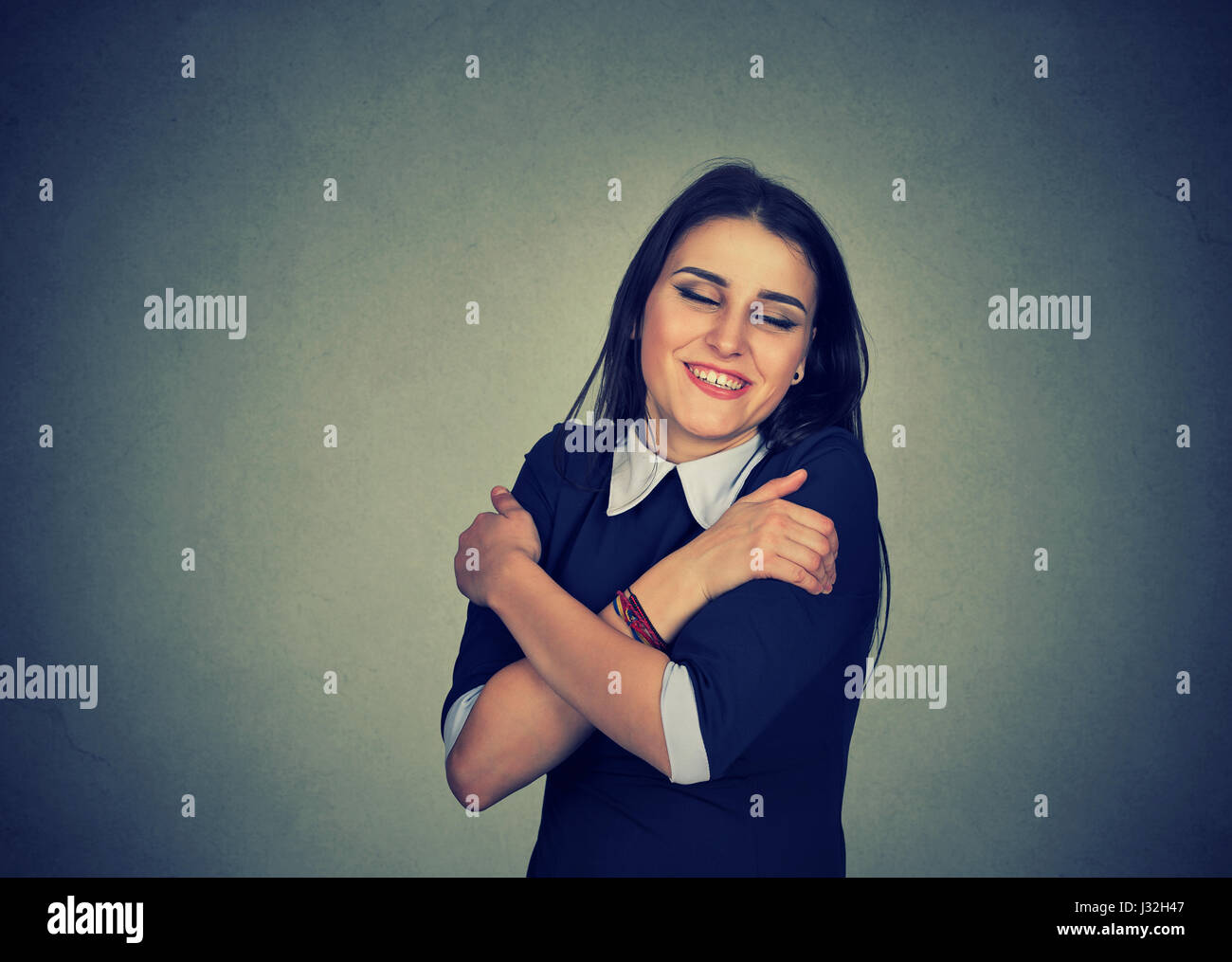 Closeup portrait confident smiling woman holding hugging herself