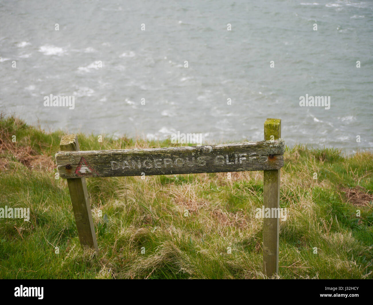 A sign warning of dangerous cliffs at St Bees head, Cumbria, England Stock Photo