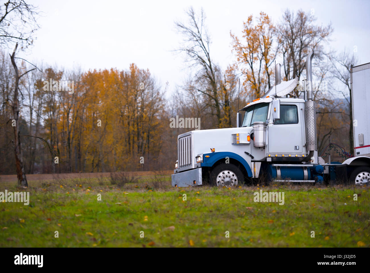Large classic professional big rig semi truck with fancy roof spoiler