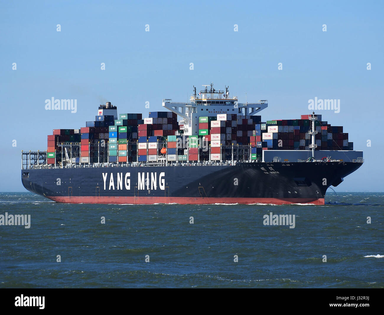 The ship YM Width, IMO 9708447, arrives at the Port of Rotterdam in 2016. The large vessel, part of international shipping, represents global maritime trade and logistics. Stock Photo