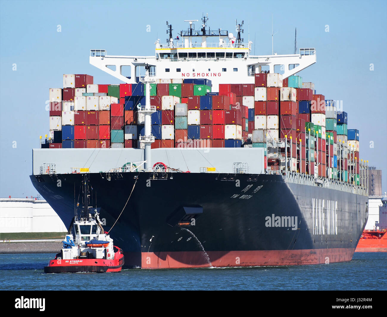 This image from 2016 shows the YM Width, a container ship with IMO number 9708447, arriving at the Port of Rotterdam. The ship is part of global maritime trade and transport. Stock Photo