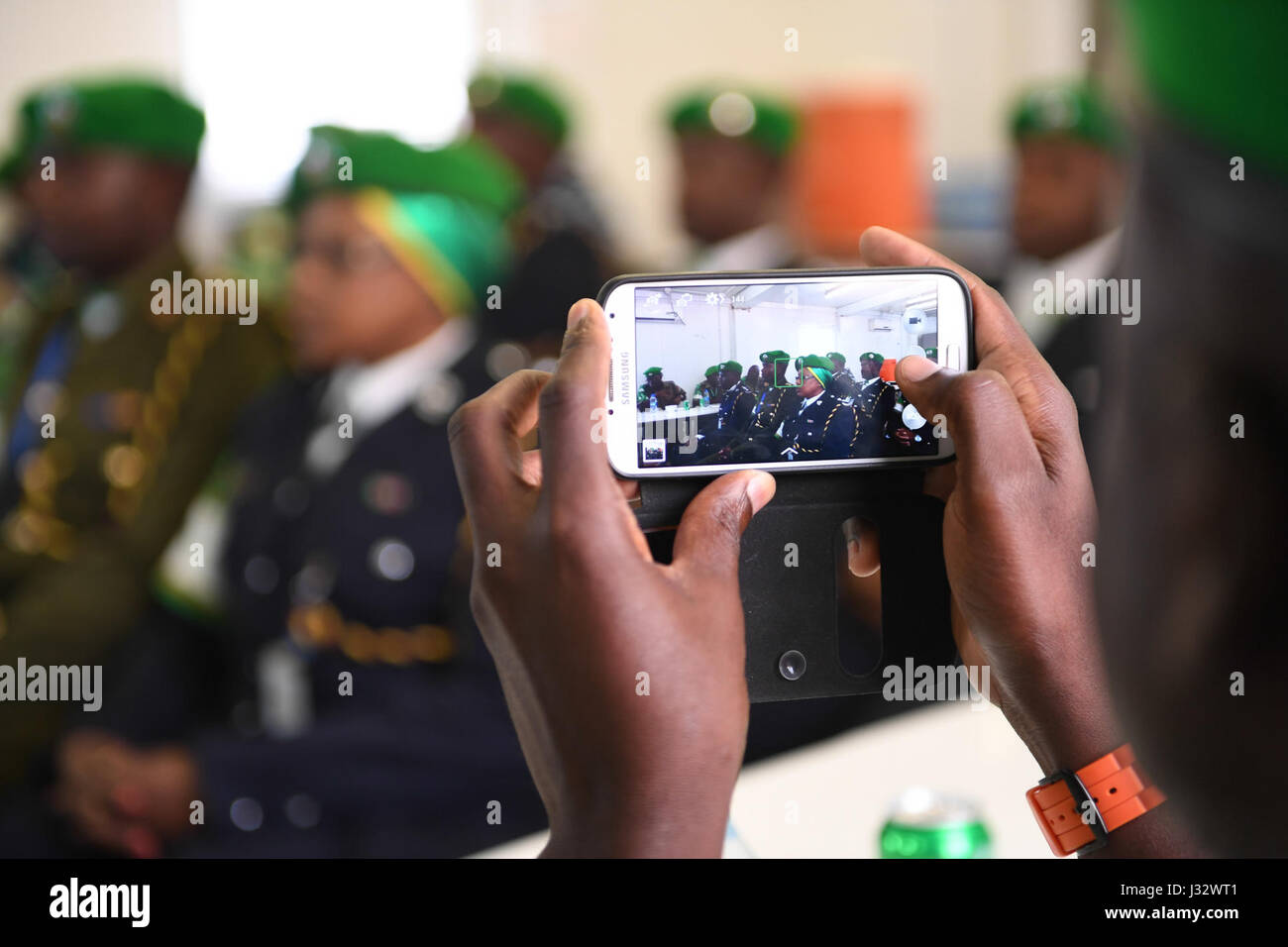 A police officer records a medals award ceremony for six Kenyan