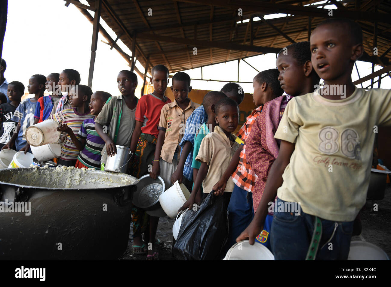 Internally displaced children in Mogadishu, Somalia, queue for food ...