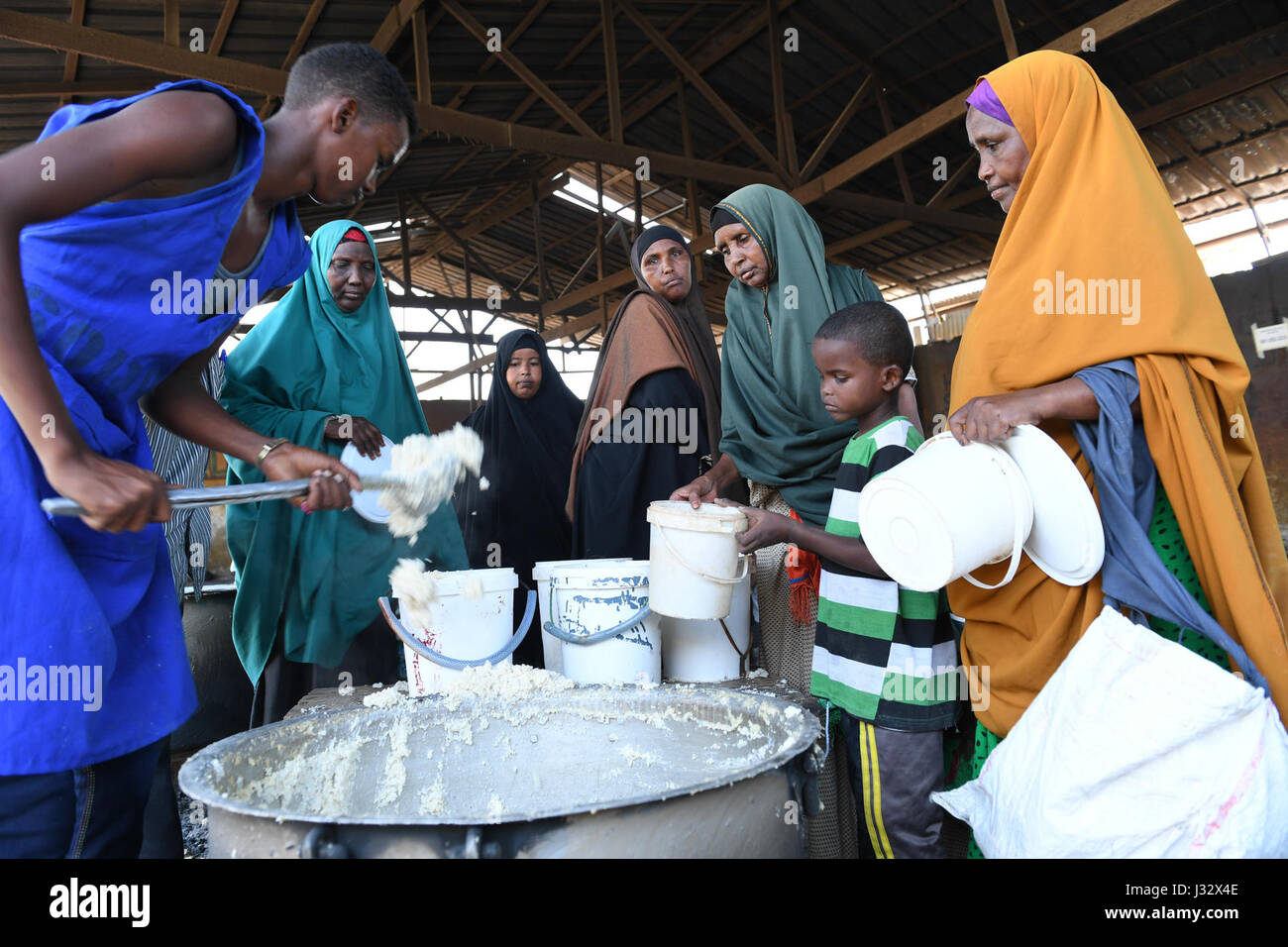 Internally displaced people receive food aid at a distribution center in Somalia's capital Mogadishu, March 9, 2017. With almost half of the Somali population in need of assistance, including 330,000 children who are acutely malnourished, the UN chief reiterated an appeal for $825 million for the support of 5.5 million people for six months. AMISOM Photo / Omar Abdisalan Stock Photo