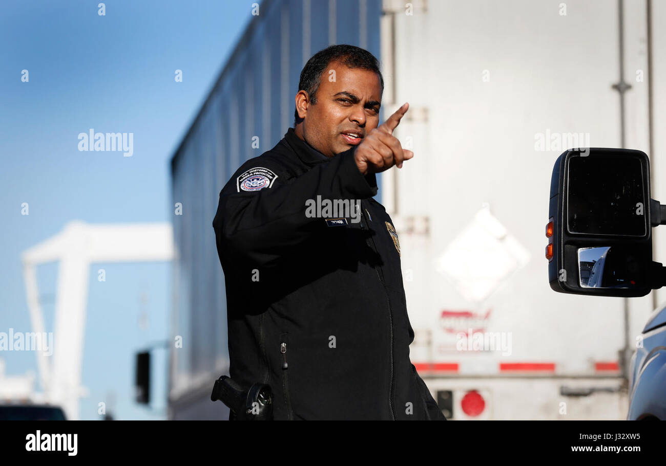 An officer with the U.S. Customs and Border Protection Office of Field Operations directs the driver an arriving truck prior to being inspected by x-ray as they arrive at NRG Stadium in preparation for Super Bowl 51 in Houston, Texas, Jan. 30, 2017. U.S. Customs and Border Protection Photo by Glenn Fawcett Stock Photo