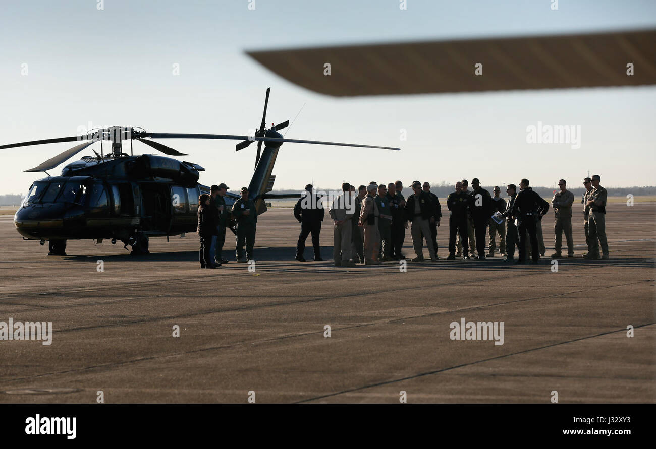 Air interdiction agents with the U.S. Customs and Border Protection, Air and Marine Operations, gather near a CBP Black Hawk helicopter with pilots and air crew with partner law enforcement agencies for a morning briefing at Ellington Field Joint Reserve Base in advance of Super Bowl LI in Houston, Texas, Jan 31, 2017. U.S. Customs and Border Protection Photo by Glenn Fawcett Stock Photo