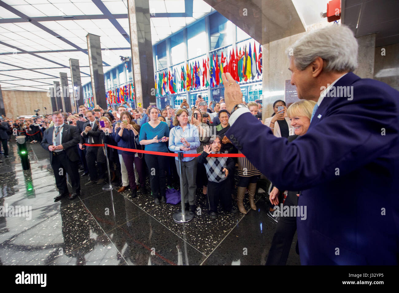 U.S. Secretary of State John Kerry waves to the crowd, as they gather in the main lobby of the Department's Harry S. Truman building, before delivering farewell remarks on January 19, 2017. Stock Photo