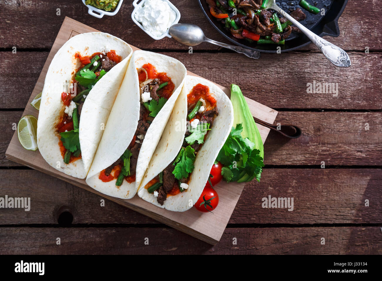 mexican steak and chicken fajitas in cast iron skillet shot top down with corn tortillas Stock Photo