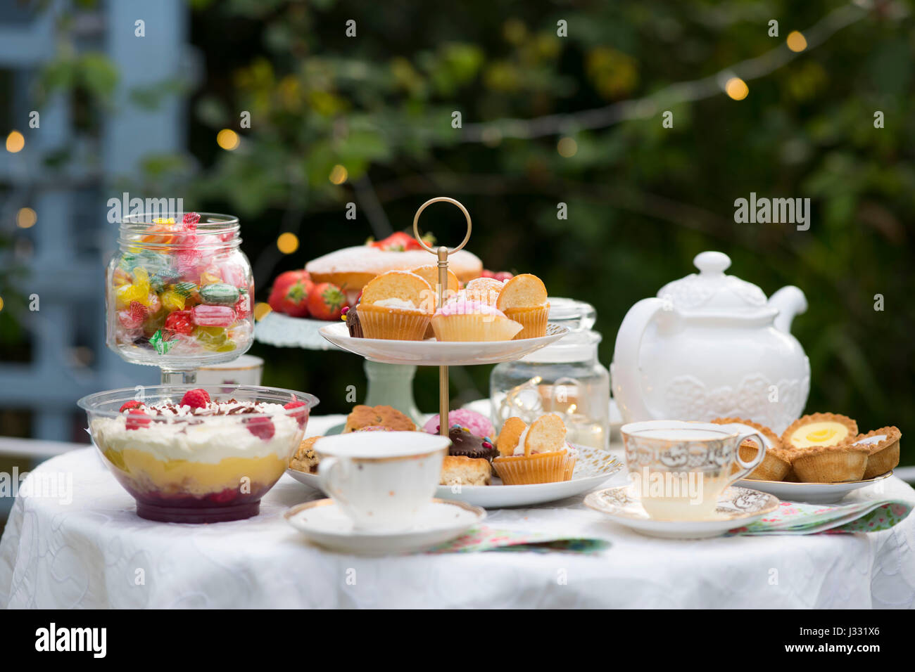 A table prepared for afternoon tea / garden party in a garden. Stock Photo