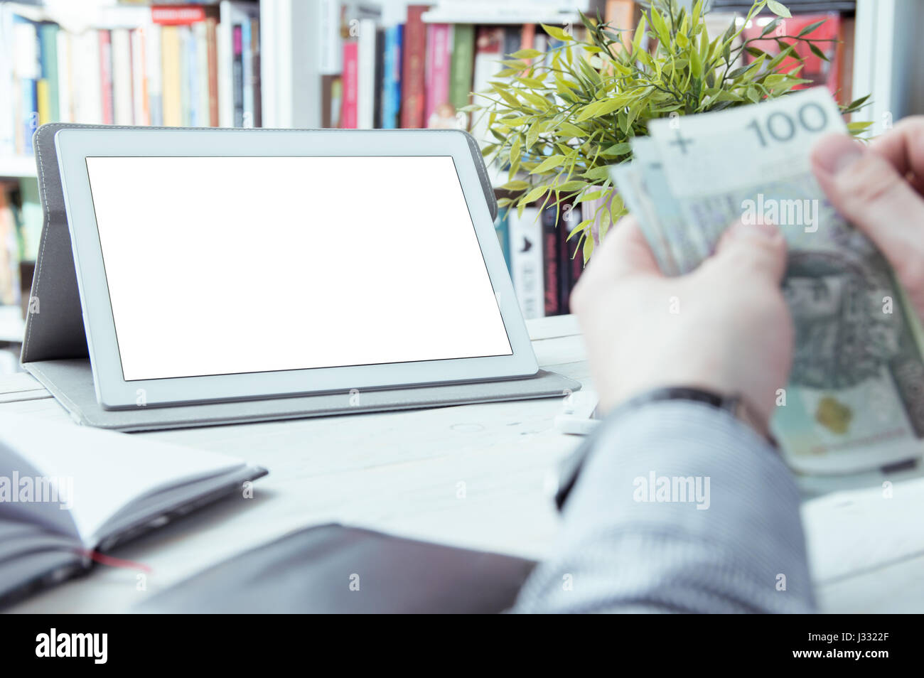 Man holds money. Empty space for your text on tablet screen. Stock Photo