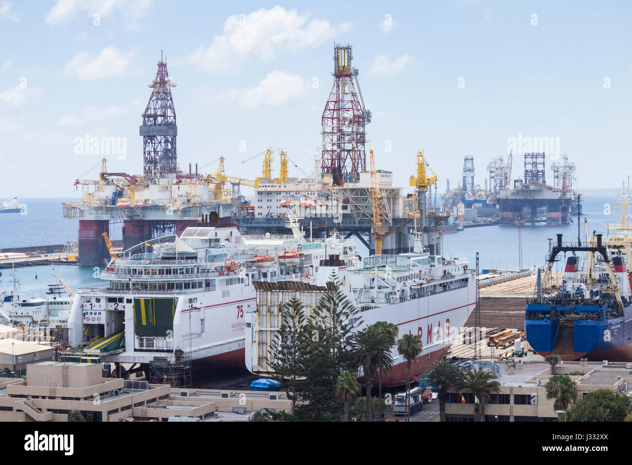 Ships in drydock with mothballed oil rigs in background in Puerto de La Luz in Las Palmas port. Gran Canaria, Canary Islands, Spain Stock Photo