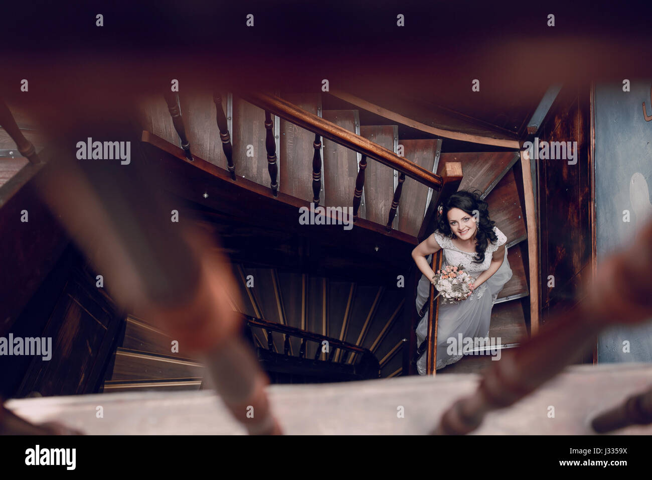 bride sitting on wooden stairs holding hands and a bouquet Stock Photo ...
