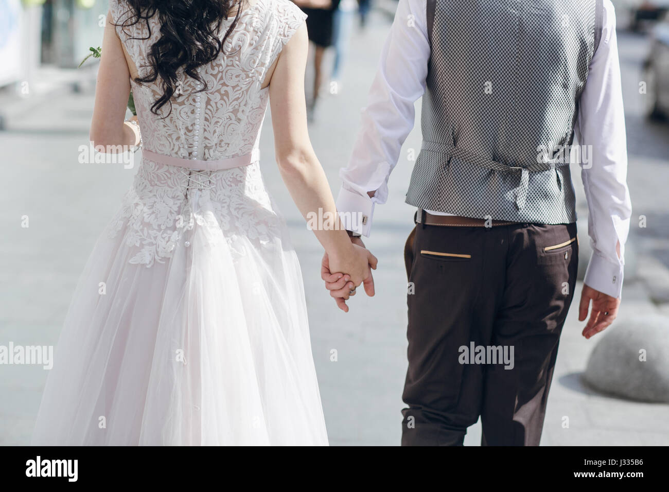 Bride and groom walking through the old town Stock Photo - Alamy