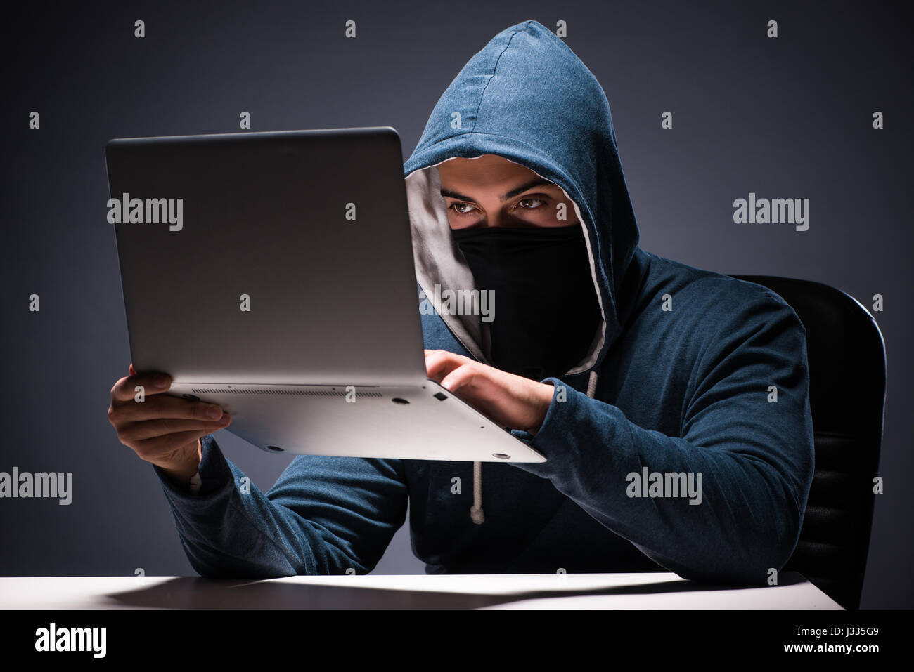 Computer hacker working in dark room Stock Photo - Alamy